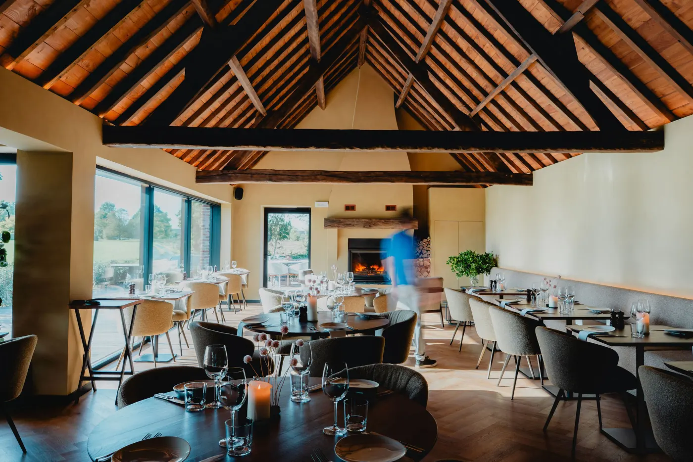 De zaal van Brasserie Éclat onder het houten dak, met gedekte tafels en grote ramen